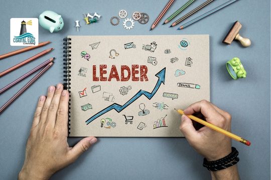 Leader writing on a notepad with the word leader on the front